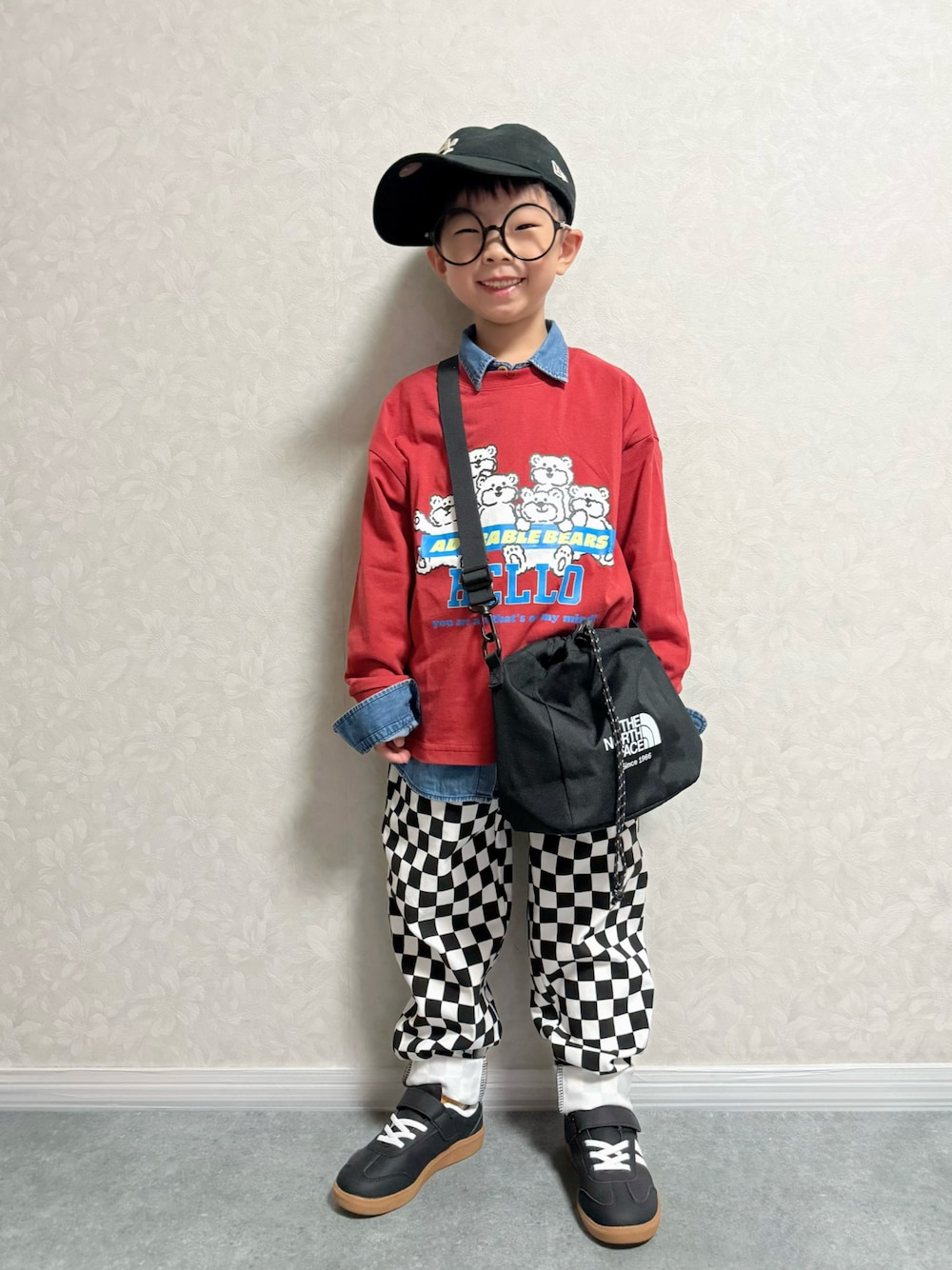 レッド系のTシャツ/カットソー、ブラック系のショルダーバッグ、ブラック系のスウェットパンツを着用したキッズの秋コーディネートの1枚目の写真
