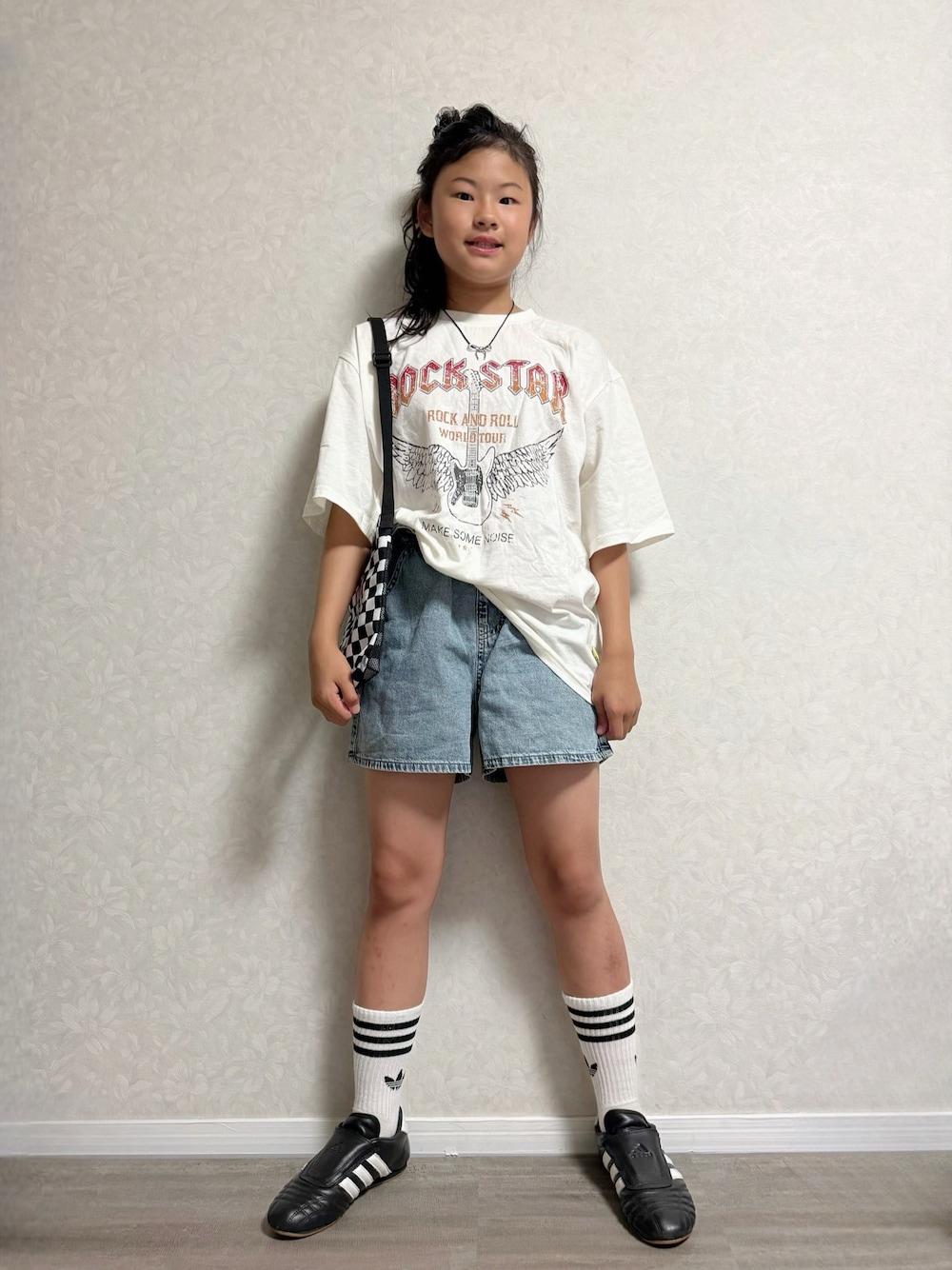 ブラック系のスニーカー、ホワイト系のTシャツ/カットソー、その他のショルダーバッグを着用したキッズの夏コーディネートの1枚目の写真