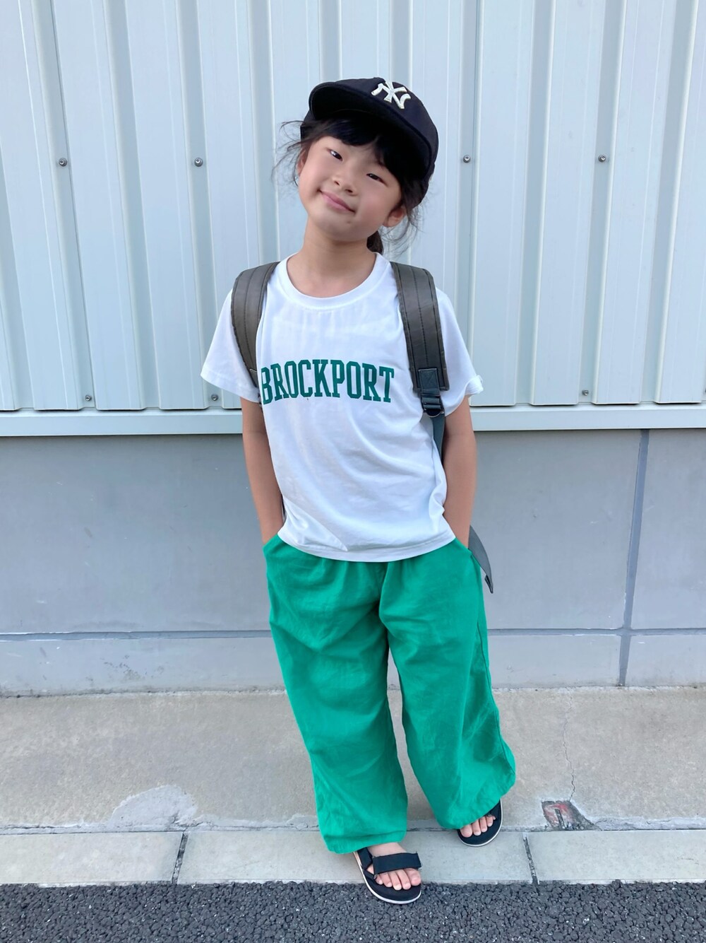 ホワイト系のTシャツ/カットソー、グレー系のバックパック/リュック、グリーン系のパンツを着用したキッズの夏コーディネートの1枚目の写真