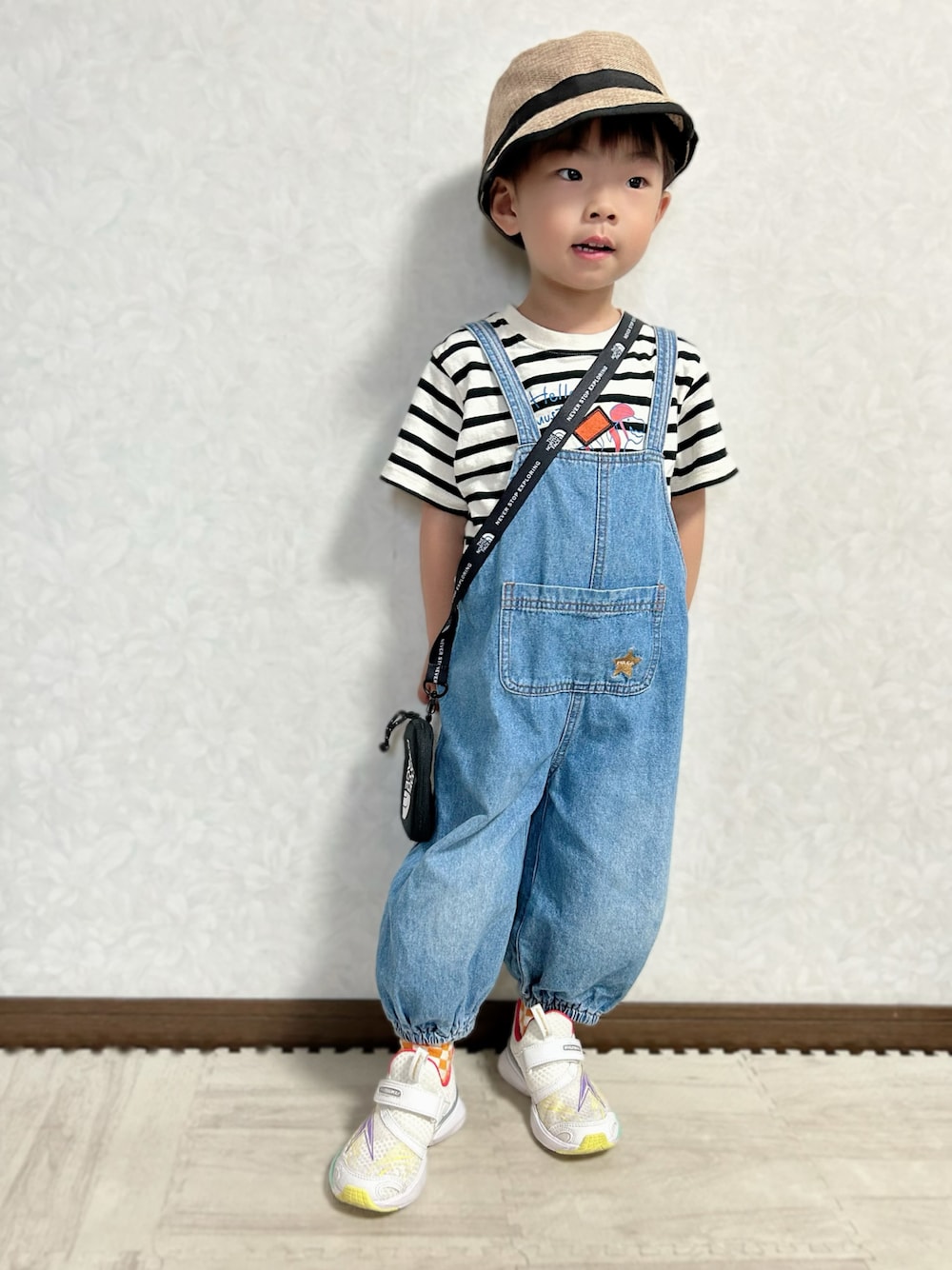 ベージュ系のTシャツ/カットソー、ブルー系のサロペット/オーバーオール、ホワイト系のスニーカーを着用したキッズの秋コーディネートの1枚目の写真