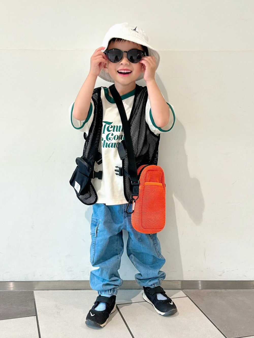 ホワイト系のTシャツ/カットソー、ブラック系のベスト、ブルー系のデニムパンツを着用したキッズの春コーディネートの1枚目の写真
