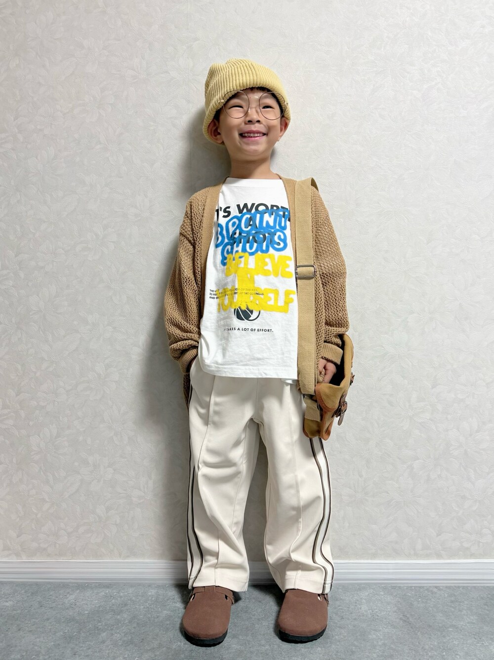 ブラウン系のショルダーバッグ、ホワイト系のTシャツ/カットソー、ブラウン系のカーディガン/ボレロを着用したキッズの秋コーディネートの1枚目の写真