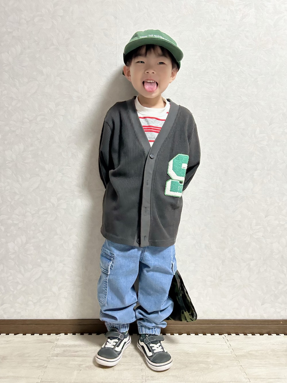 グレー系のTシャツ/カットソー、ブラック系のカーディガン/ボレロ、ブルー系のデニムパンツを着用したキッズの春コーディネートの1枚目の写真