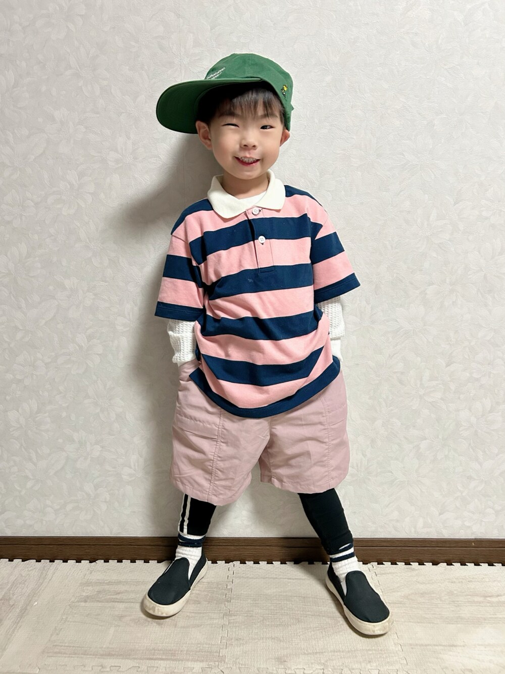 ピンク系のポロシャツ、ピンク系のパンツ、ブラック系のスリッポンを着用したキッズの春コーディネートの1枚目の写真