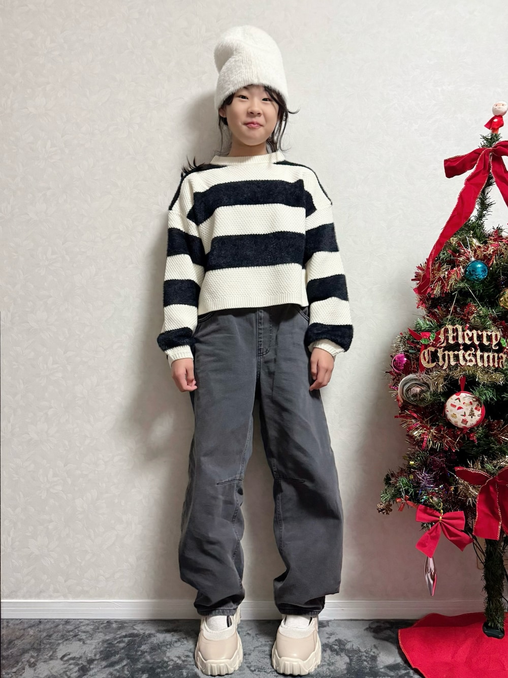 ベージュ系のその他シューズ、ブラック系のニット/セーター、グレー系のデニムパンツを着用したキッズの冬コーディネートの1枚目の写真