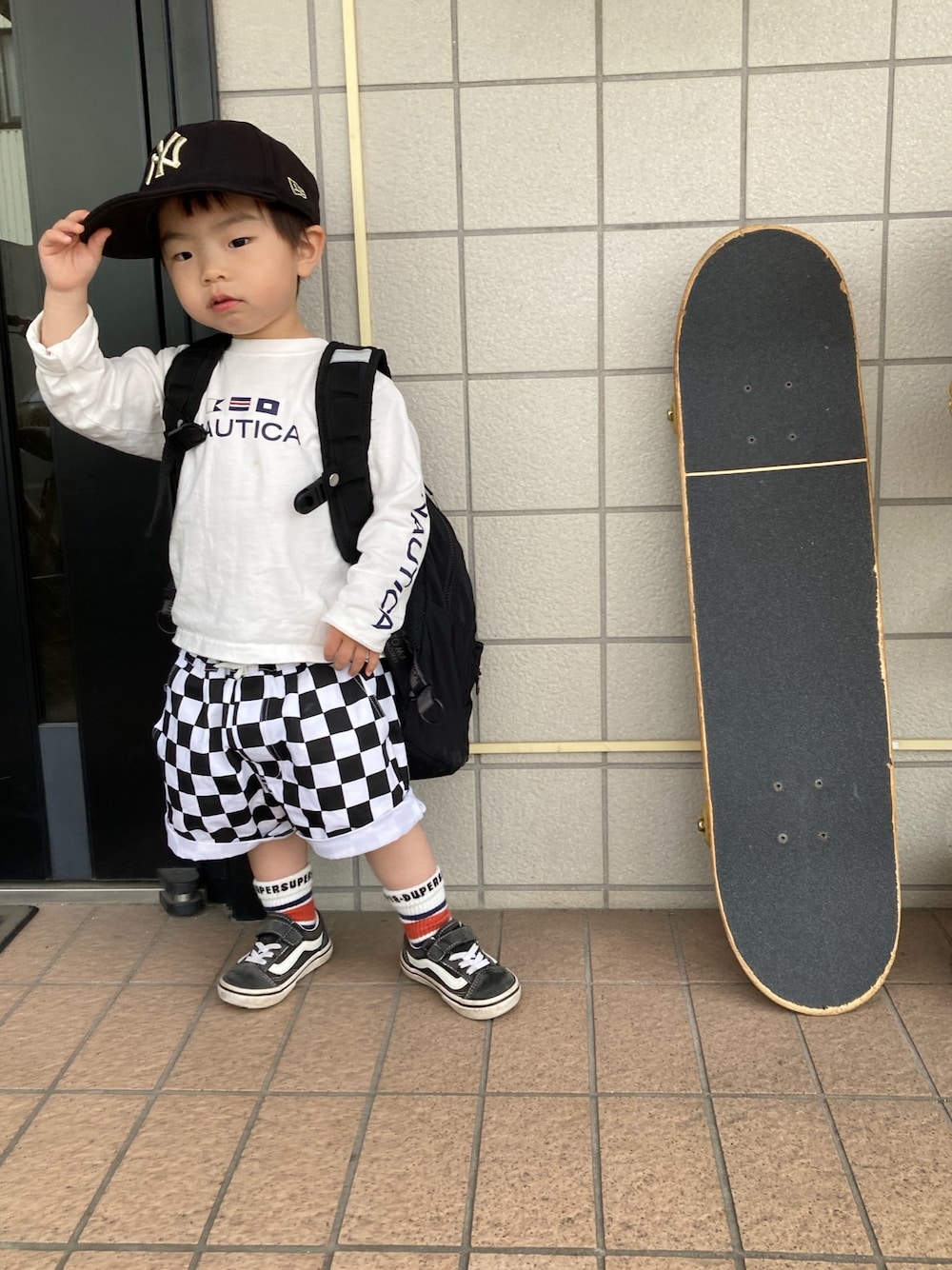 ホワイト系のTシャツ/カットソー、ブラック系のバックパック/リュック、ブラック系のその他パンツを着用したキッズの春コーディネートの1枚目の写真
