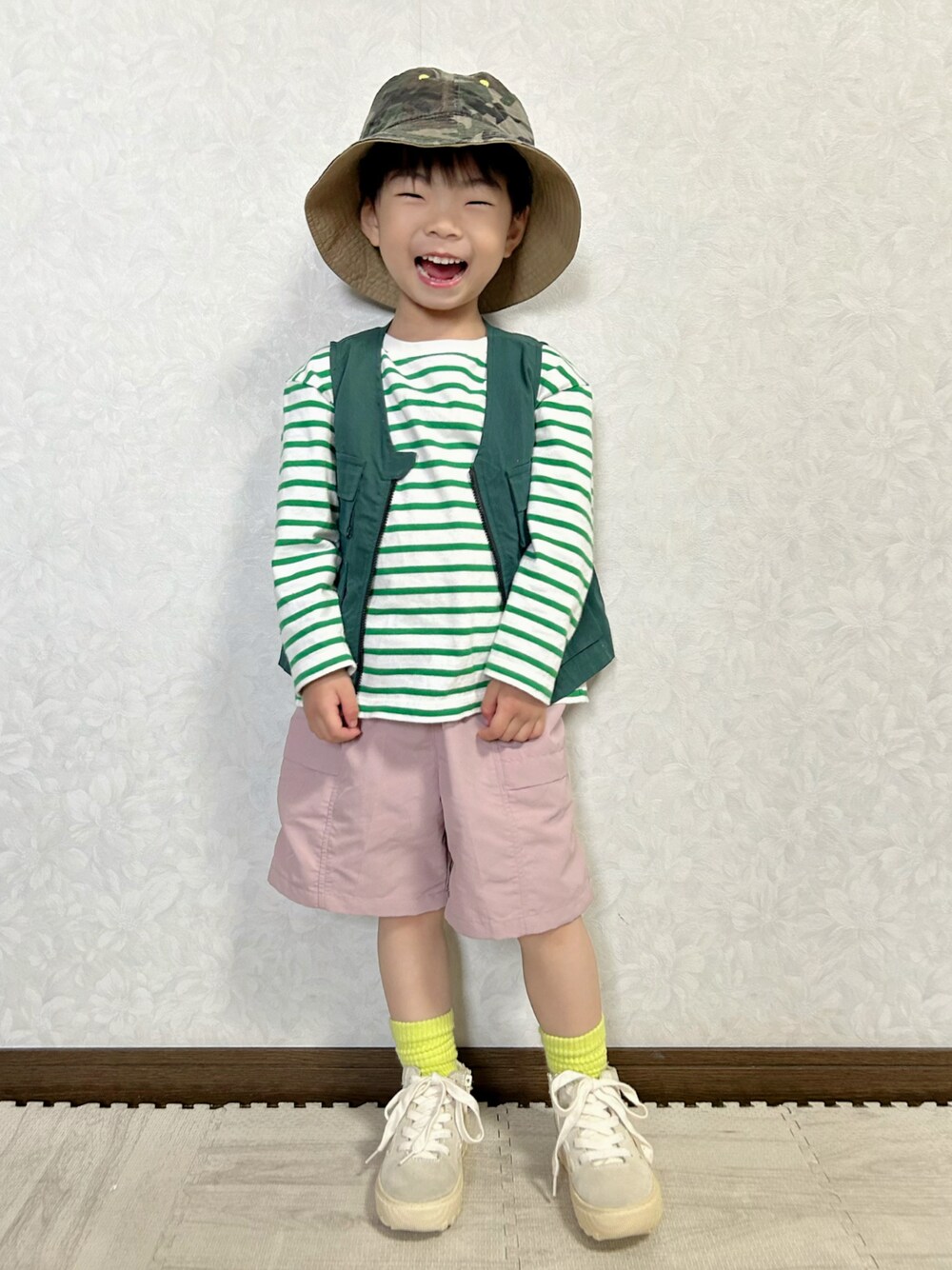 グリーン系のTシャツ/カットソー、グリーン系のベスト、ピンク系のパンツを着用したキッズの春コーディネートの1枚目の写真
