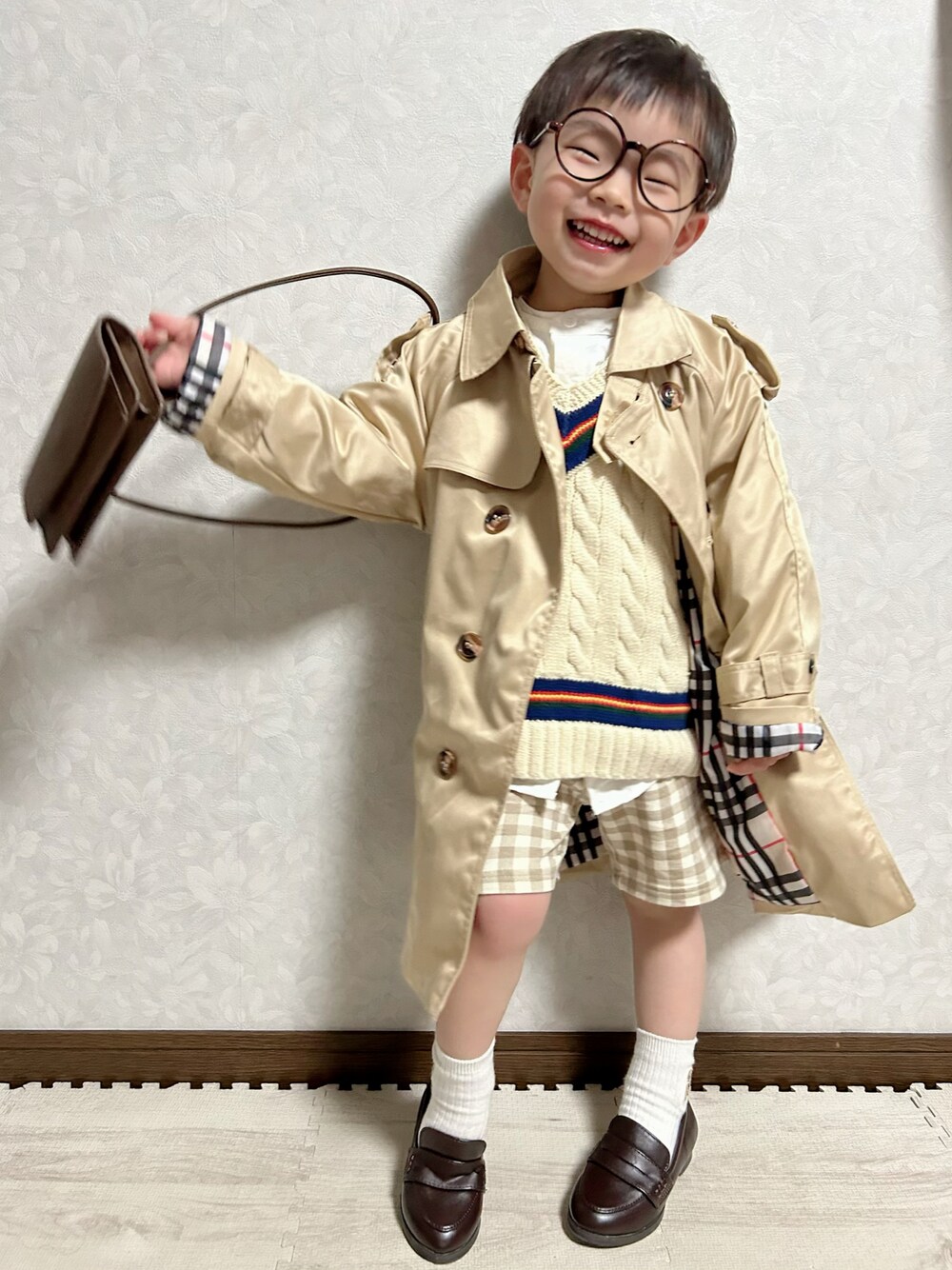 ホワイト系のシャツ/ブラウス、ホワイト系のベスト、ベージュ系のトレンチコートを着用したキッズの春コーディネートの1枚目の写真