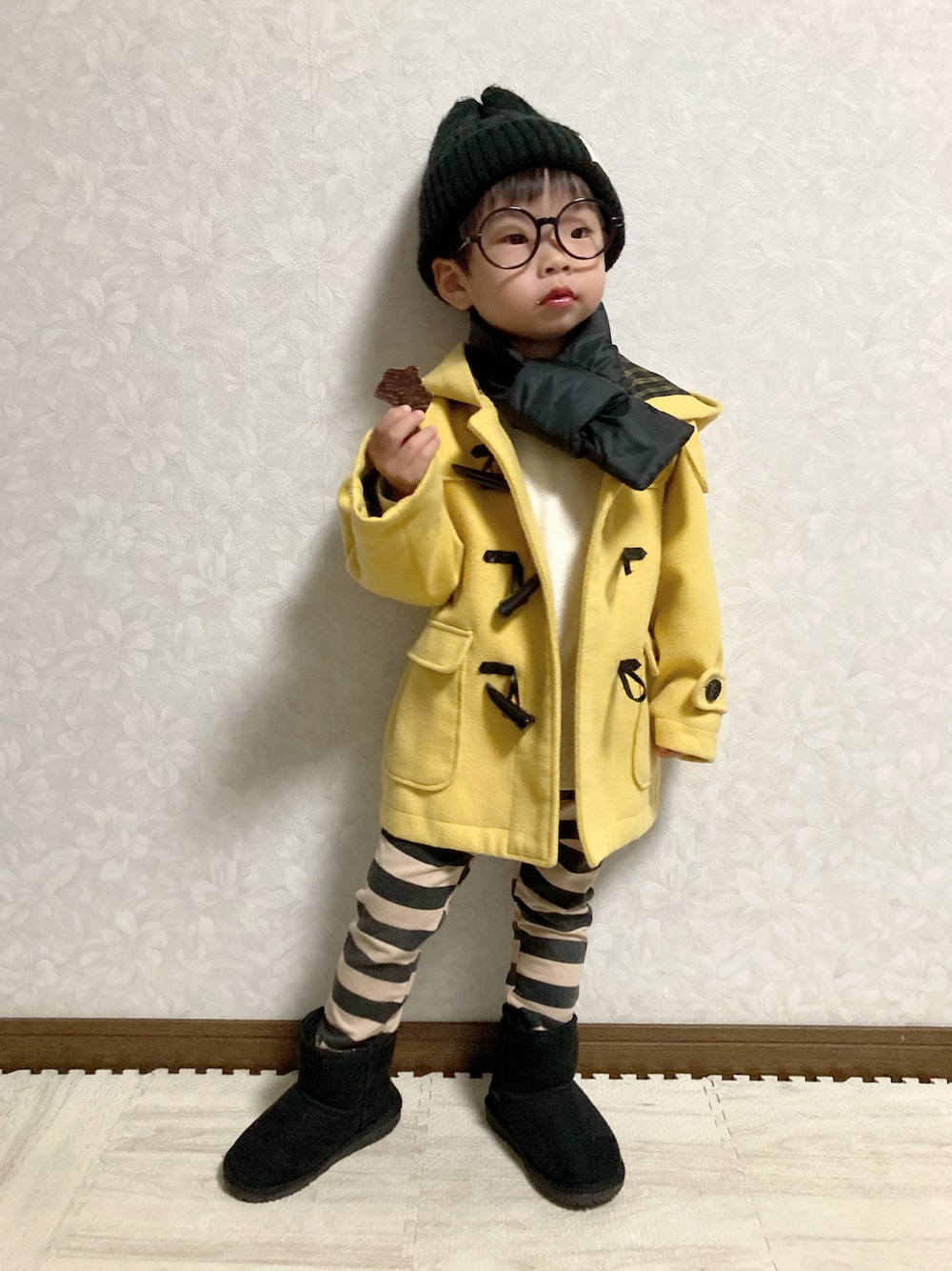 ホワイト系のニット/セーター、イエロー系のダッフルコート、ブラック系のその他パンツを着用したキッズの冬コーディネートの1枚目の写真