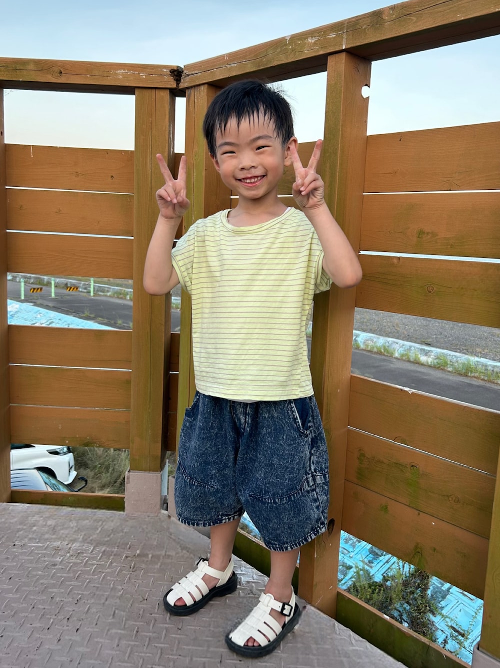 イエロー系のTシャツ/カットソー、ブルー系のデニムパンツ、ホワイト系のサンダルを着用したキッズの夏コーディネートの1枚目の写真