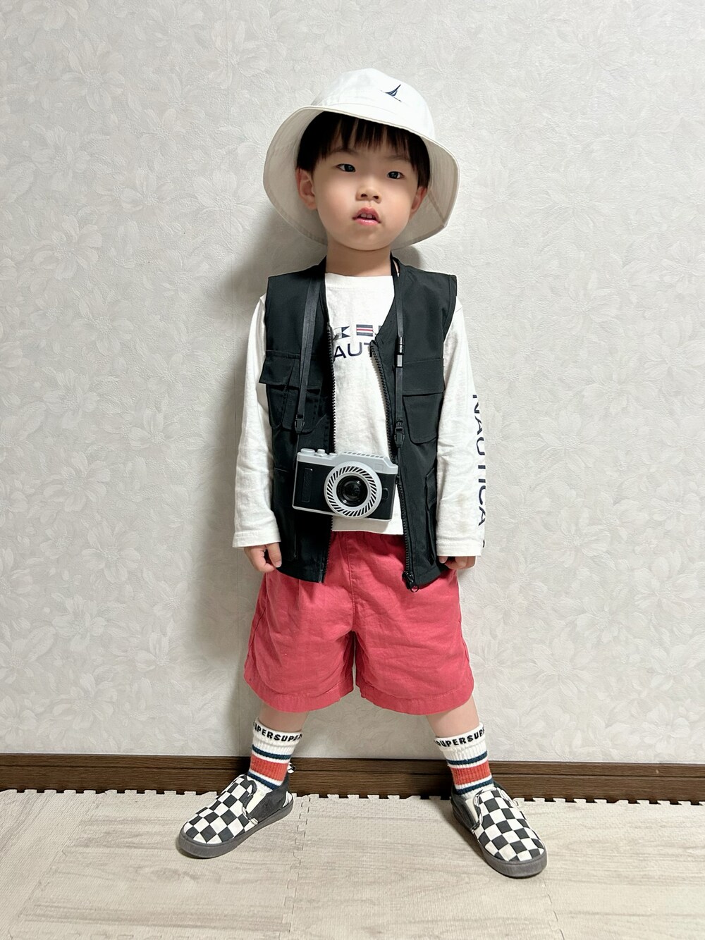 ホワイト系のTシャツ/カットソー、ブラック系のベスト、レッド系のパンツを着用したキッズの春コーディネートの1枚目の写真