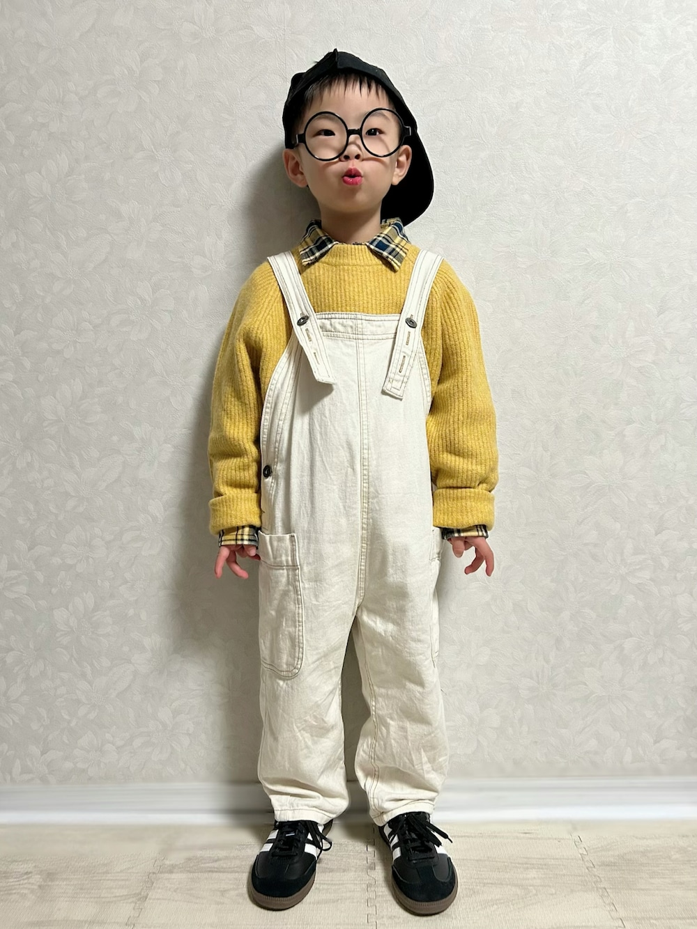 イエロー系のシャツ/ブラウス、イエロー系のニット/セーター、ホワイト系のサロペット/オーバーオールを着用したキッズの冬コーディネートの1枚目の写真