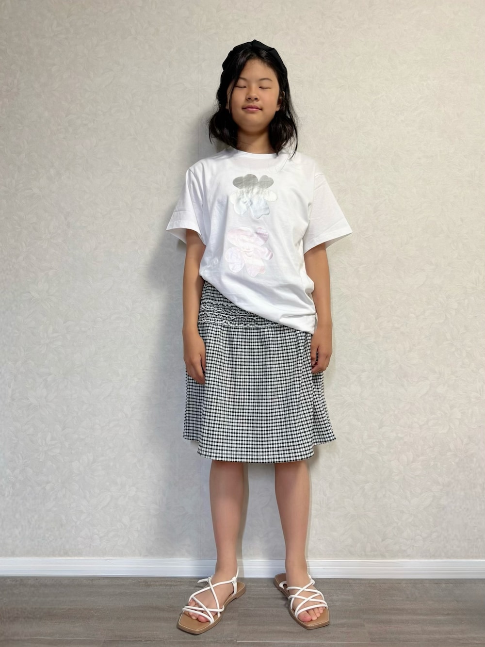 グレー系のTシャツ/カットソー、ホワイト系のスカート、ホワイト系のサンダルを着用したキッズの春コーディネートの1枚目の写真