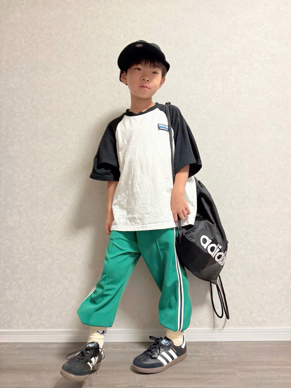 ホワイト系のTシャツ/カットソー、ブラック系のバックパック/リュック、グリーン系のスウェットパンツを着用したキッズの秋コーディネートの1枚目の写真