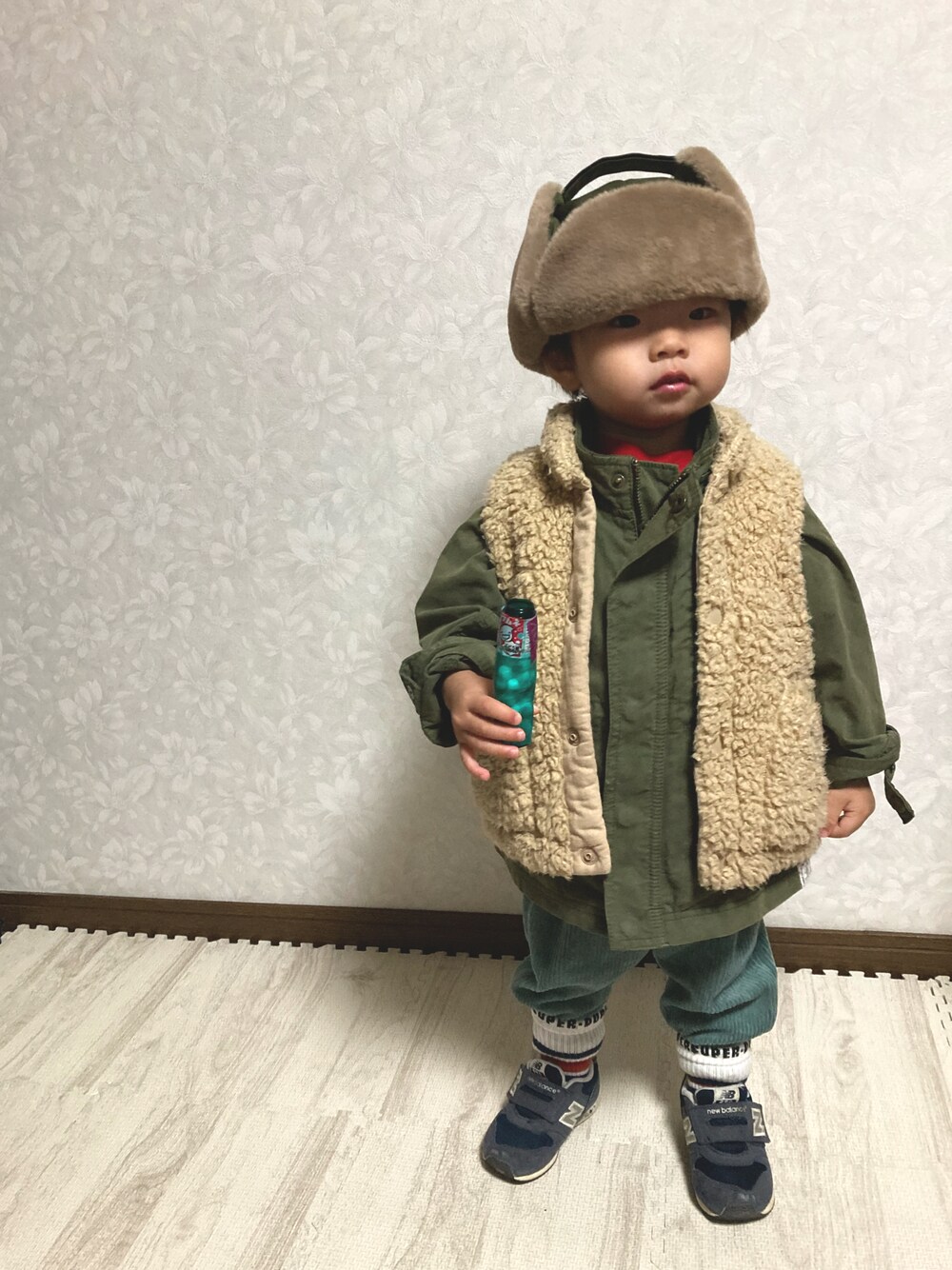 レッド系のスウェット、グリーン系のミリタリージャケット、グリーン系のその他パンツを着用したキッズの秋コーディネートの1枚目の写真