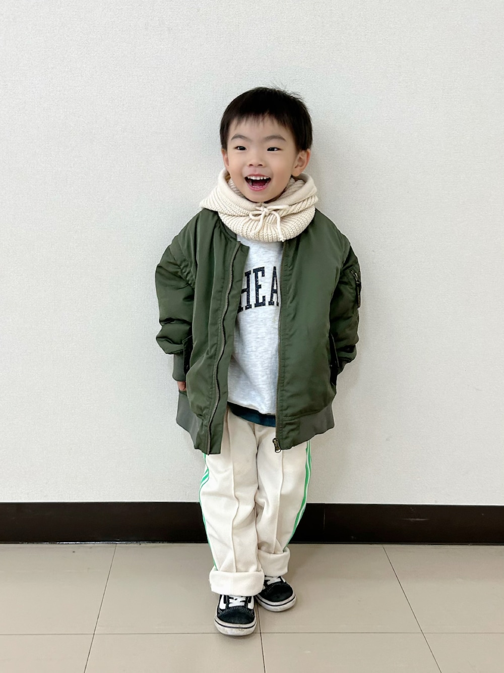 グレー系のスウェット、グリーン系のポロシャツ、グリーン系のMA-1を着用したキッズの秋コーディネートの1枚目の写真