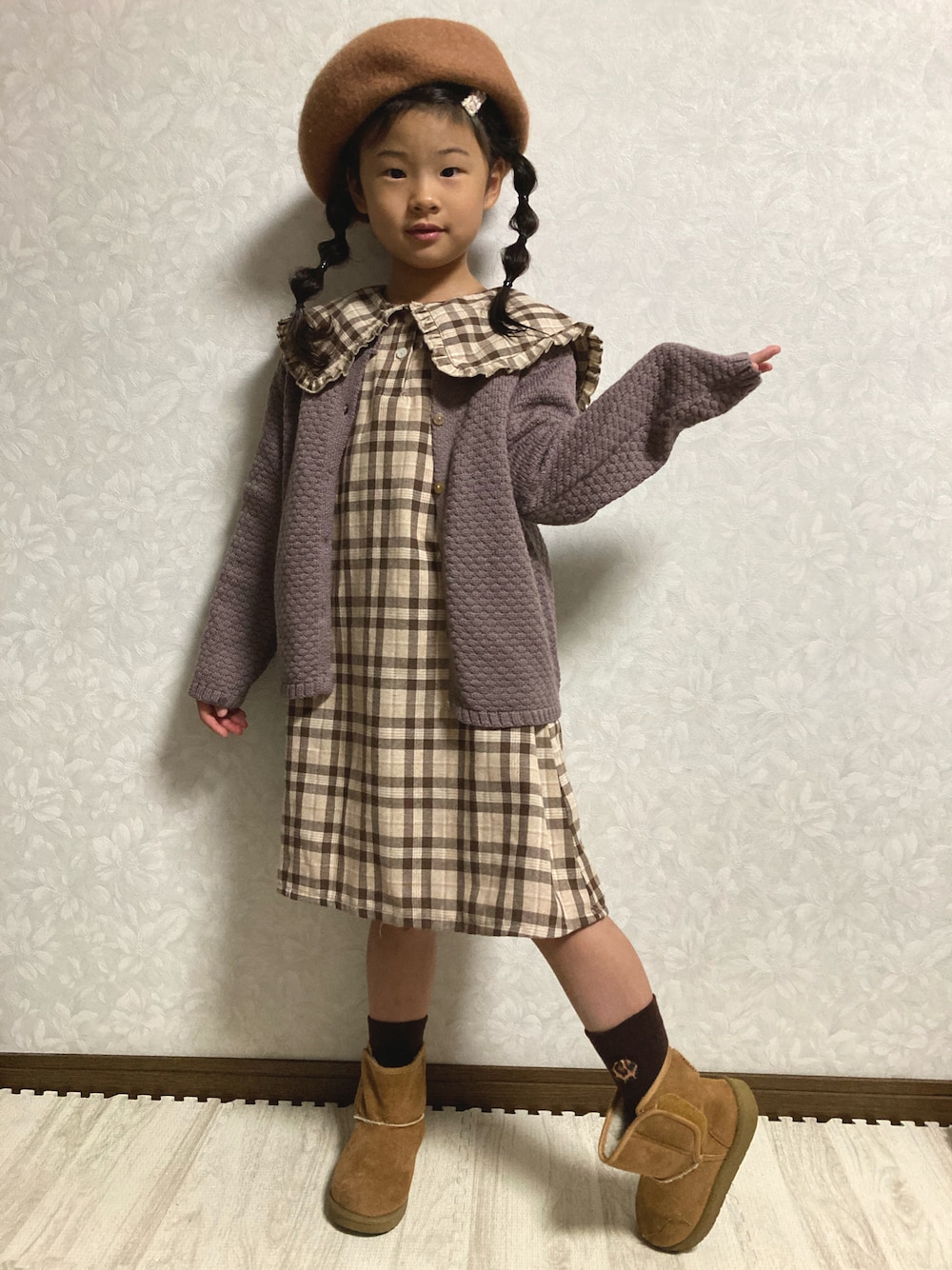 ブラウン系のシャツワンピース、グレー系のカーディガン/ボレロ、ベージュ系のブーツを着用したキッズの秋コーディネートの1枚目の写真
