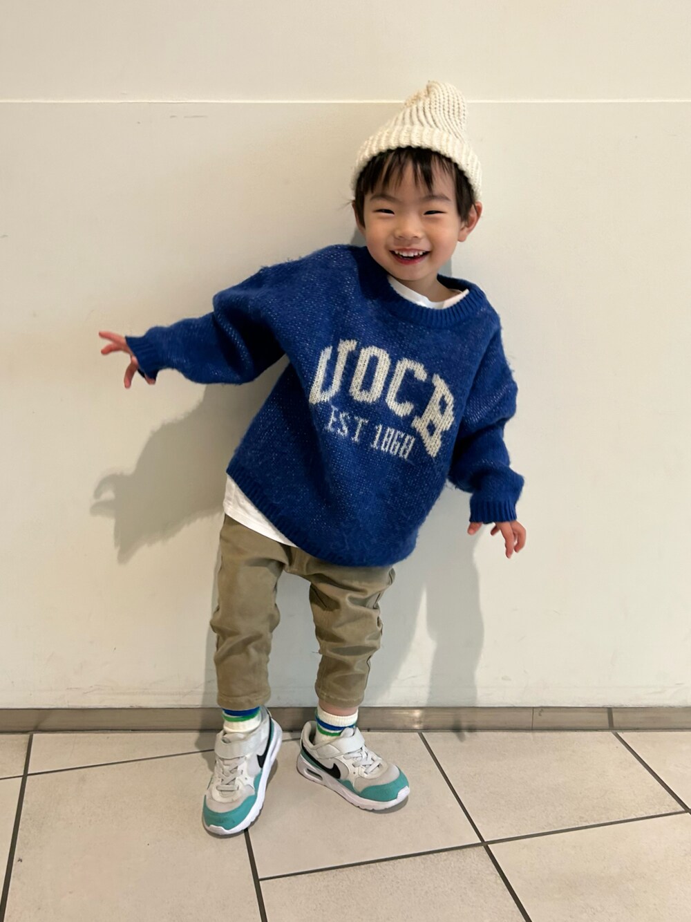 ブルー系のニット/セーター、ベージュ系のその他パンツ、ホワイト系のスニーカーを着用したキッズの冬コーディネートの1枚目の写真