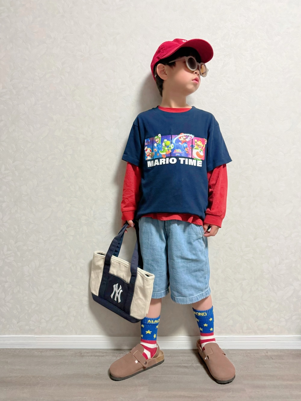 レッド系のTシャツ/カットソー、ホワイト系のショルダーバッグ、ブルー系のTシャツ/カットソーを着用したキッズの春コーディネートの1枚目の写真