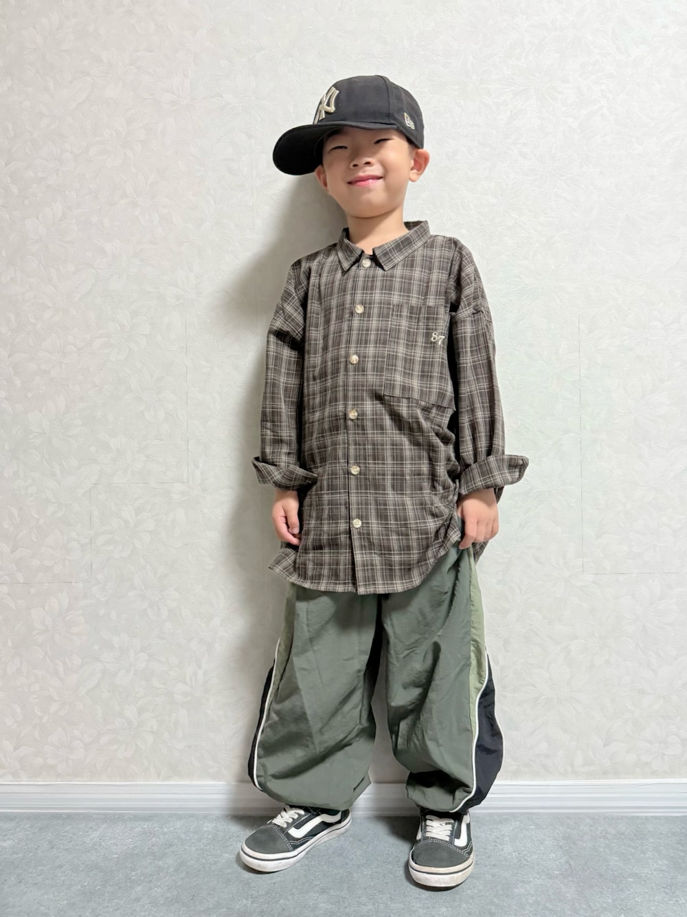 ブラウン系のシャツ/ブラウス、グリーン系のその他パンツ、ブラック系のスニーカーを着用したキッズの秋コーディネートの1枚目の写真