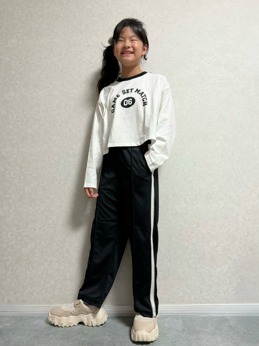 ベージュ系のその他シューズ、ホワイト系のTシャツ/カットソー、ブラック系のパンツを着用したキッズの秋コーディネートの1枚目の写真