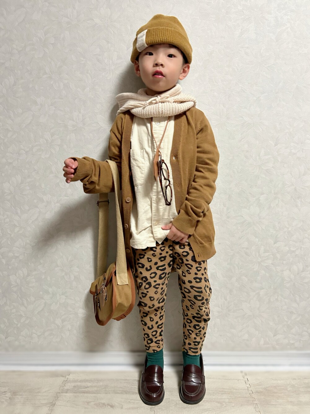 ブラウン系のカーディガン/ボレロ、ホワイト系のシャツ/ブラウス、ブラウン系のスウェットパンツを着用したキッズの秋コーディネートの1枚目の写真