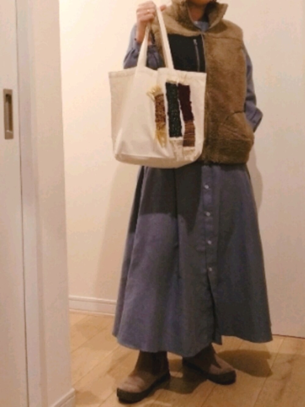 ホワイト系のトートバッグ、ブラウン系のその他アウター、ブルー系のシャツワンピースを着用したレディースの秋コーディネートの1枚目の写真