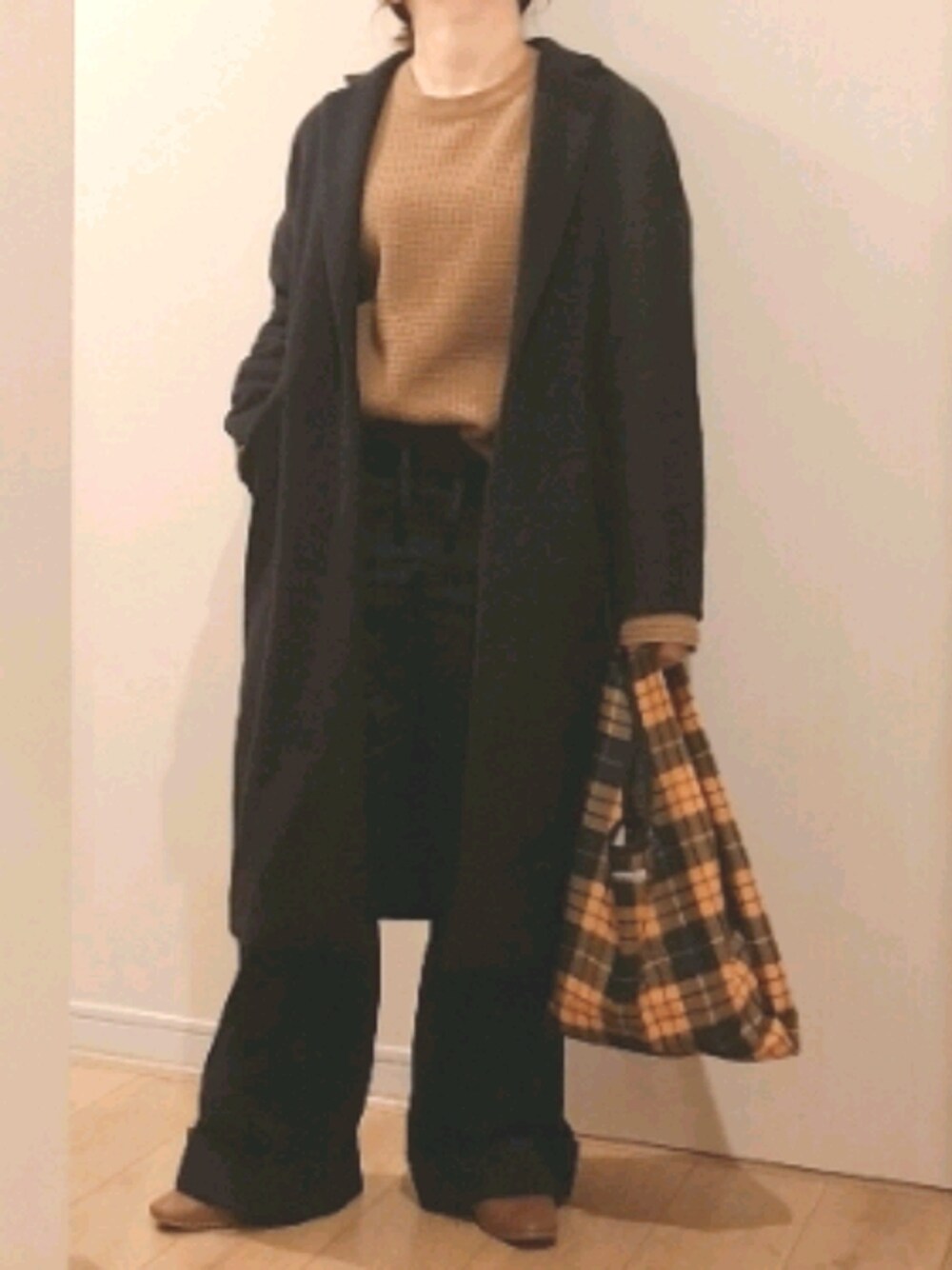 ブラウン系のニット/セーター、ブルー系のパンツ、ブラック系のチェスターコートを着用したレディースの冬コーディネートの1枚目の写真