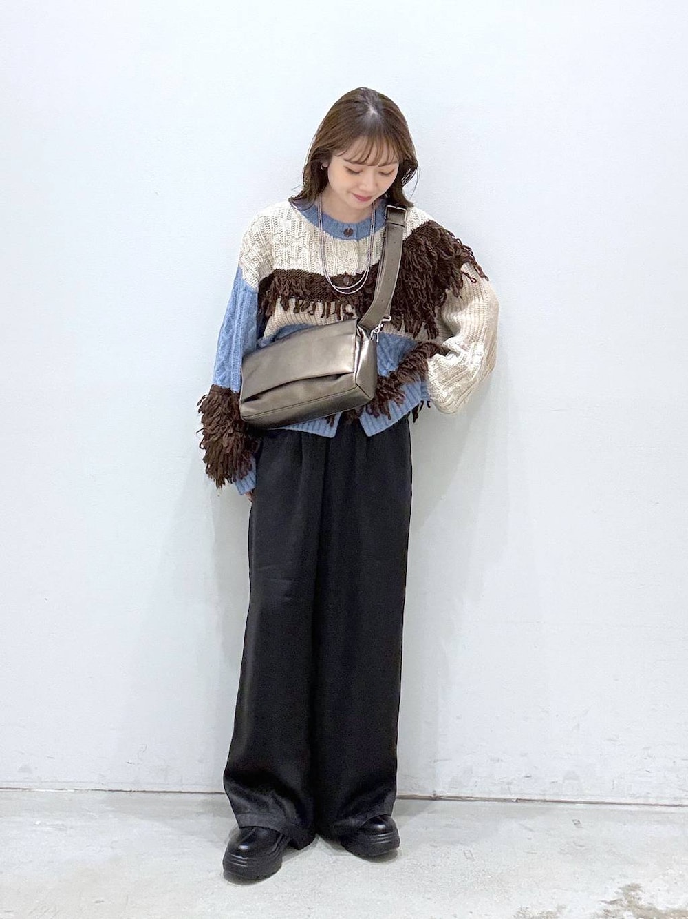 その他のショルダーバッグ、ブルー系のカーディガン/ボレロ、ブラック系のブーツを着用したレディースの秋コーディネートの1枚目の写真