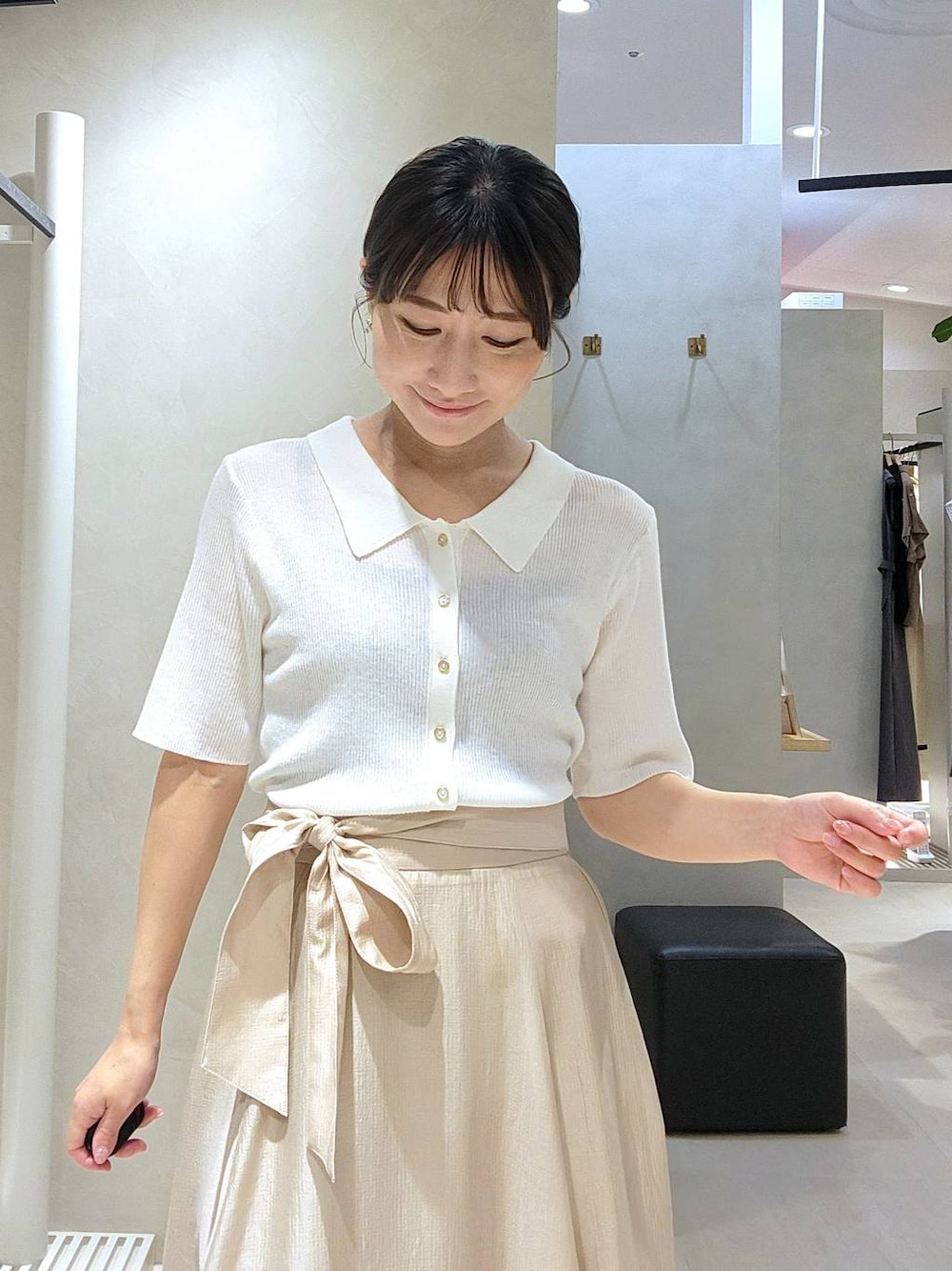 ホワイト系のカーディガン/ボレロ、ベージュ系のスカートを着用したレディースの春コーディネートの1枚目の写真