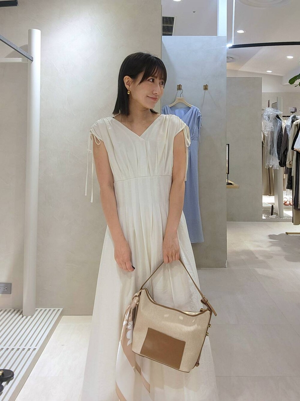 ベージュ系のショルダーバッグ、ベージュ系のワンピースを着用したレディースの夏コーディネートの1枚目の写真