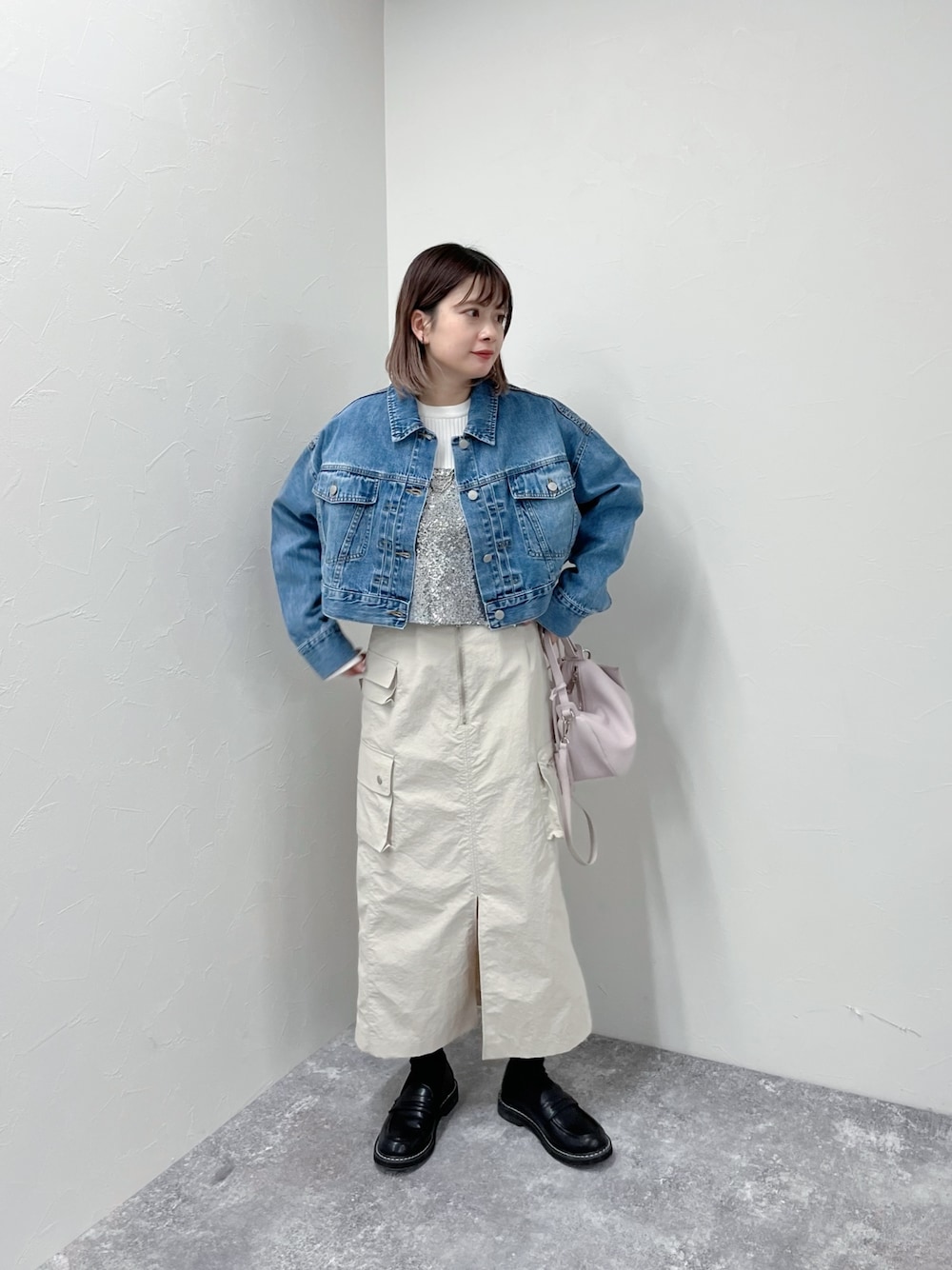 ブルー系のデニムジャケット、シルバー系のシャツ/ブラウス、ベージュ系のスカートを着用したレディースの春コーディネートの1枚目の写真
