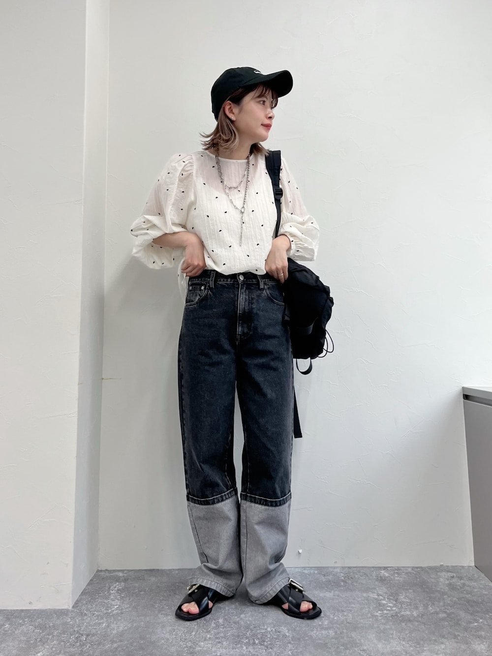 ブラック系のデニムパンツ、ホワイト系のシャツ/ブラウス、ブラック系のキャップを着用したレディースの冬コーディネートの1枚目の写真