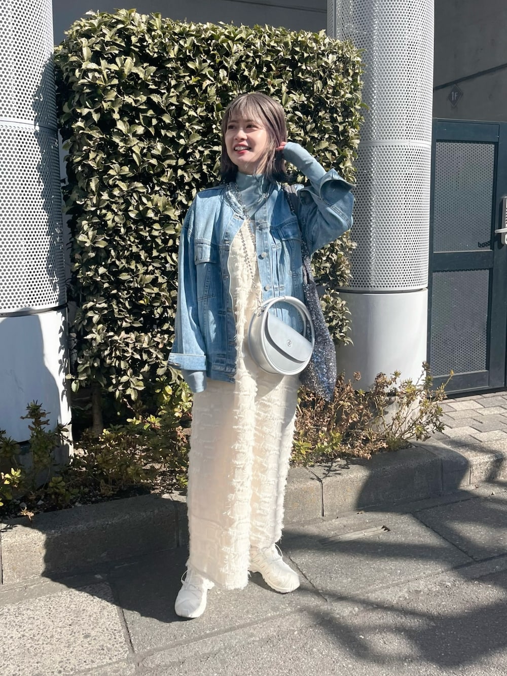 ブルー系のデニムジャケット、ホワイト系のワンピース、ブルー系のTシャツ/カットソーを着用したレディースの春コーディネートの1枚目の写真
