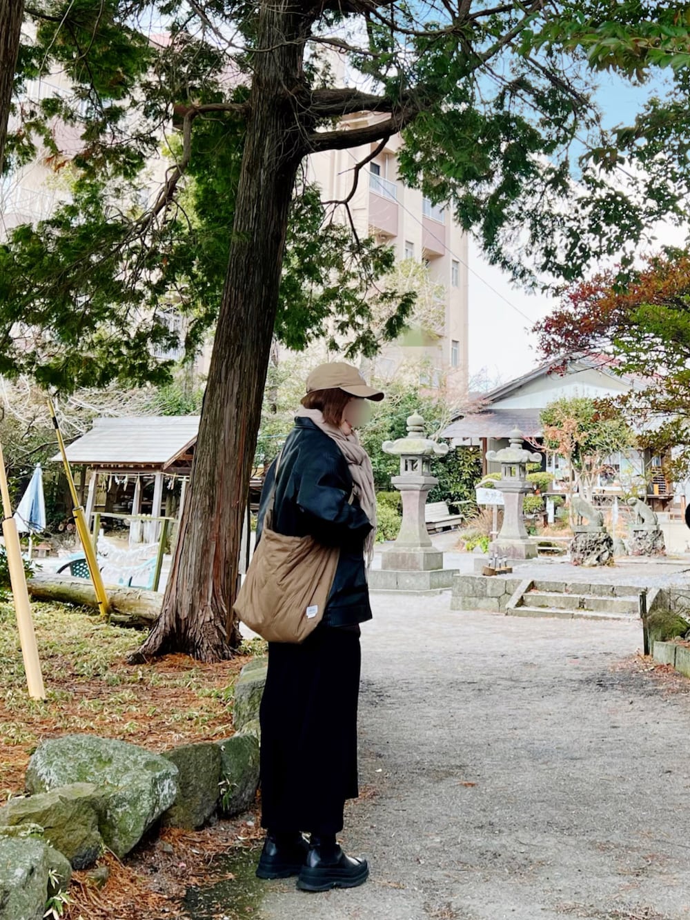 ブラック系のジャケット/アウター、ブラック系のワンピース、ベージュ系のキャップを着用したレディースの冬コーディネートの1枚目の写真