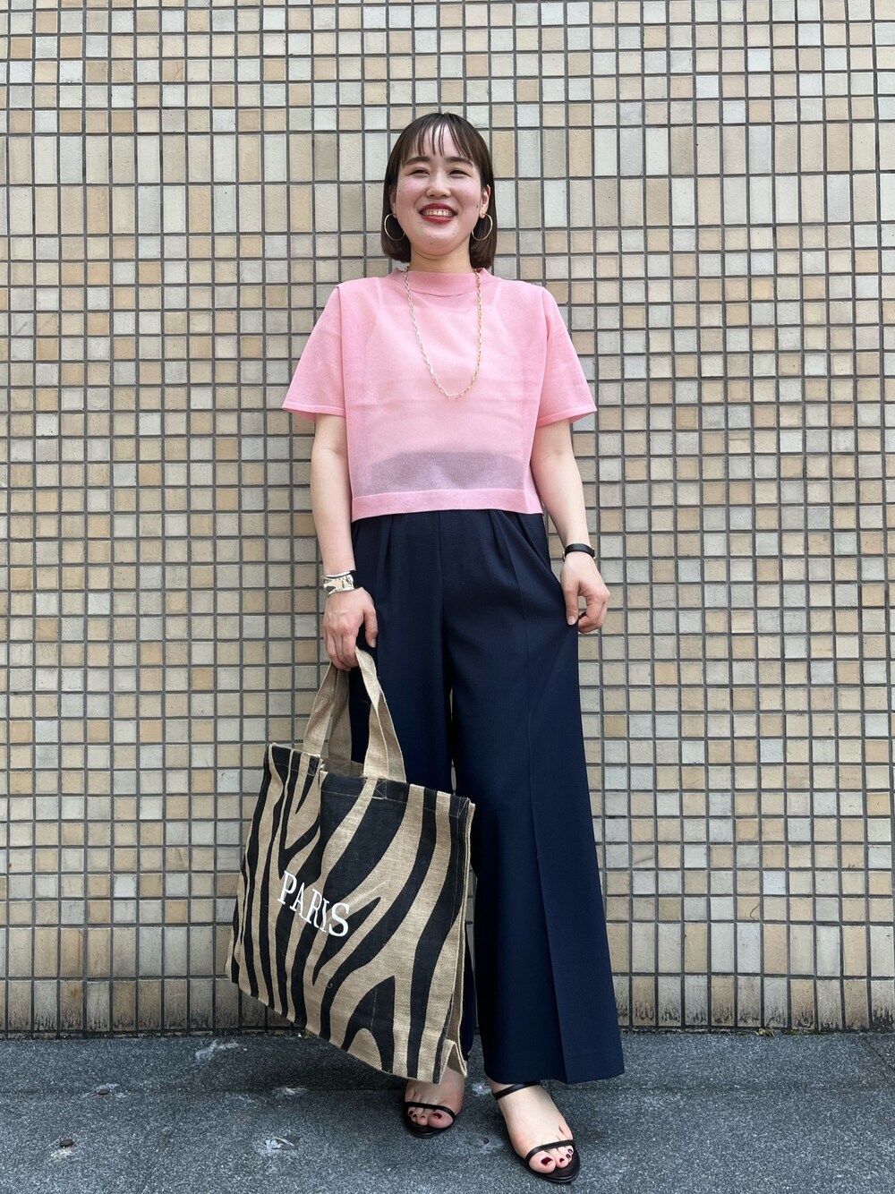 ピンク系のニット/セーター、ブルー系のその他パンツ、その他のトートバッグを着用したレディースの春コーディネートの1枚目の写真