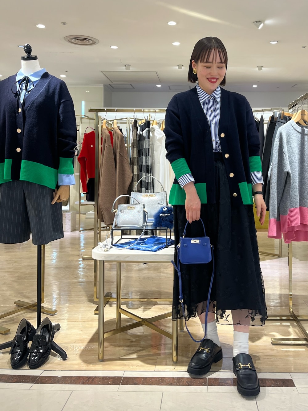 ブルー系のショルダーバッグ、ブルー系のカーディガン/ボレロ、ブルー系のシャツ/ブラウスを着用したレディースの秋コーディネートの1枚目の写真