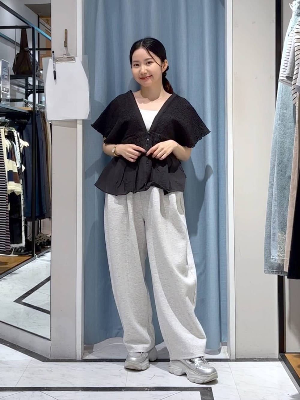 グレー系のスウェットパンツ、ブラック系のシャツ/ブラウス、シルバー系のスニーカーを着用したレディースの夏コーディネートの1枚目の写真
