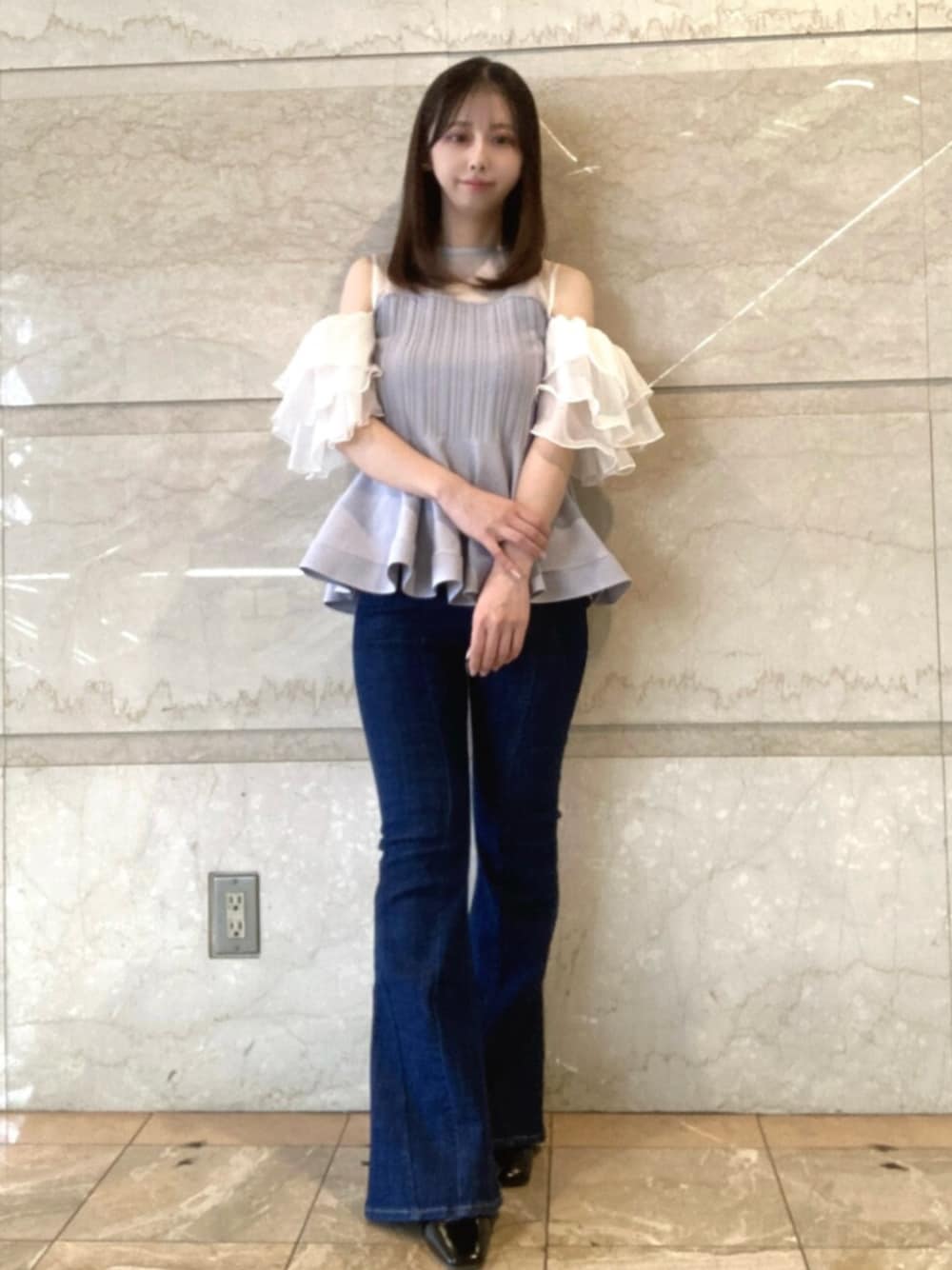 パープル系のその他トップス、ブルー系のデニムパンツ、ブラック系のサンダルを着用したレディースの春コーディネートの1枚目の写真
