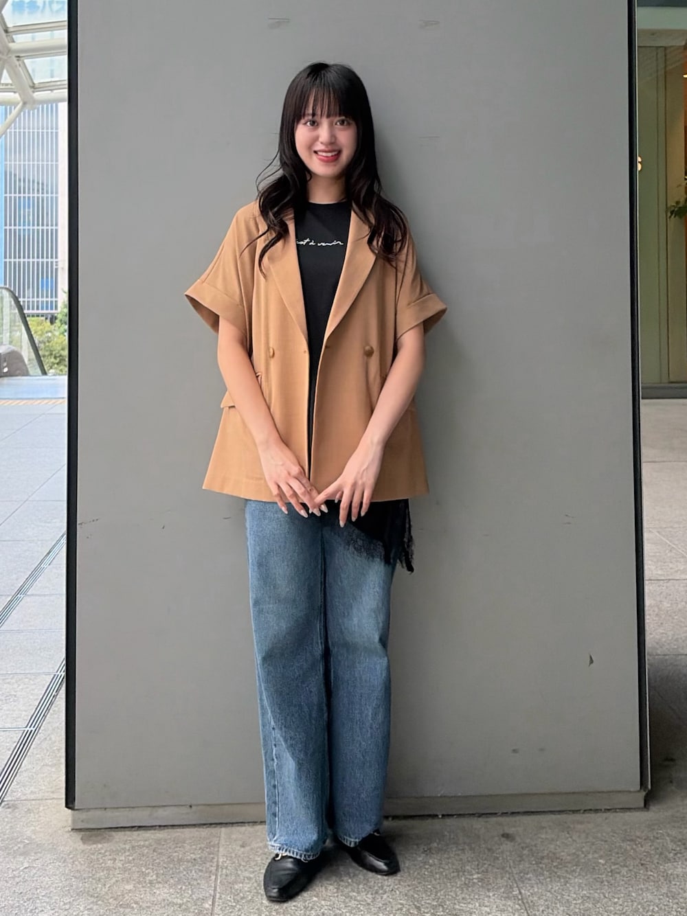 イエロー系のテーラードジャケット、ブラック系のTシャツ/カットソー、ブルー系のデニムパンツを着用したレディースの夏コーディネートの1枚目の写真