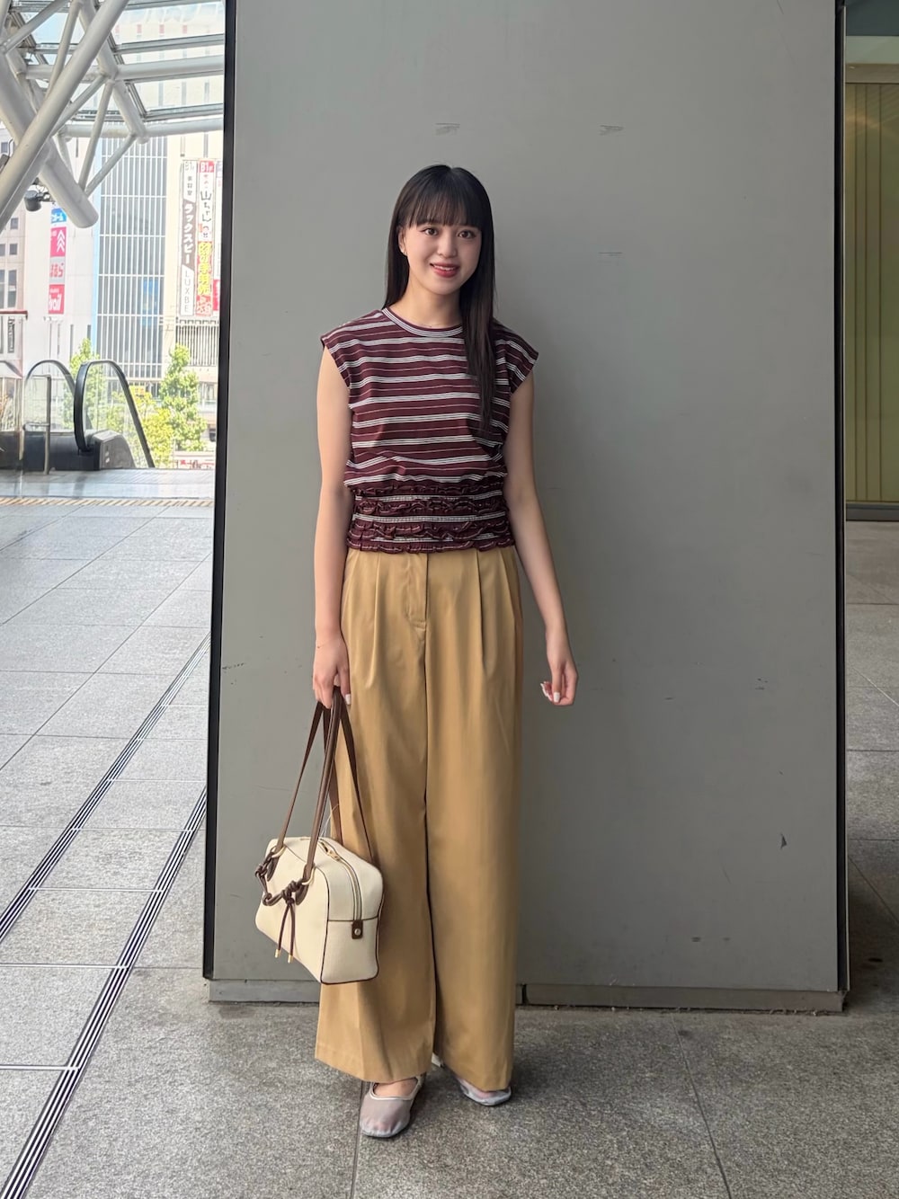 ブラウン系のTシャツ/カットソー、ベージュ系のその他パンツ、ホワイト系のボストンバッグを着用したレディースの夏コーディネートの1枚目の写真