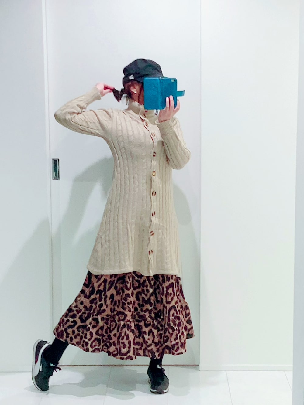 ベージュ系のワンピース/ドレス、ブラウン系のスカート、ブラック系のスニーカーを着用したレディースの秋コーディネートの1枚目の写真