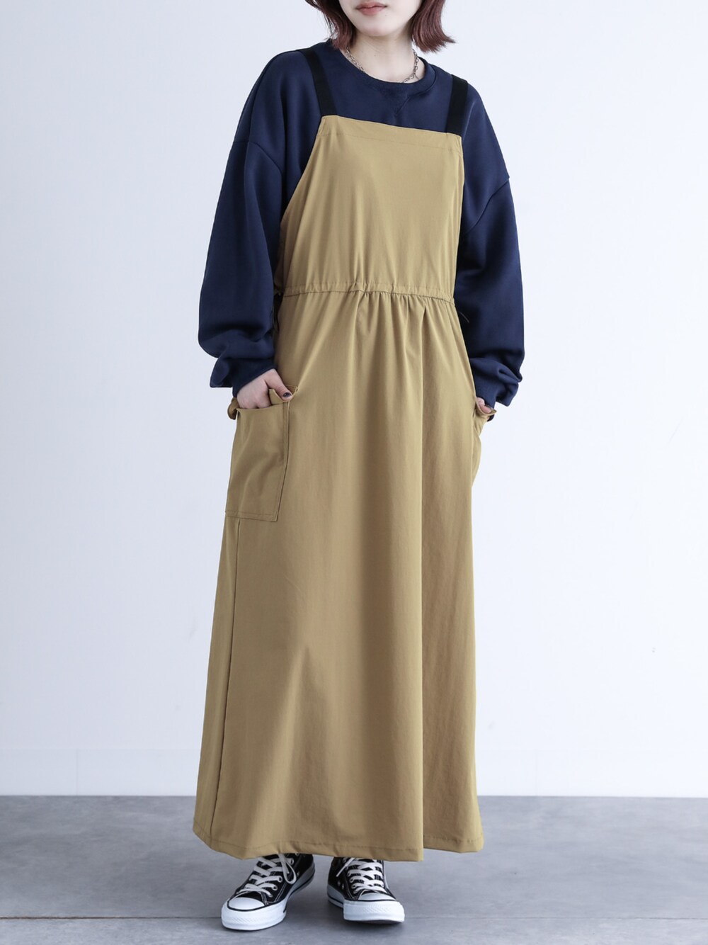 ベージュ系のジャンパースカートを着用したレディースの夏コーディネートの1枚目の写真