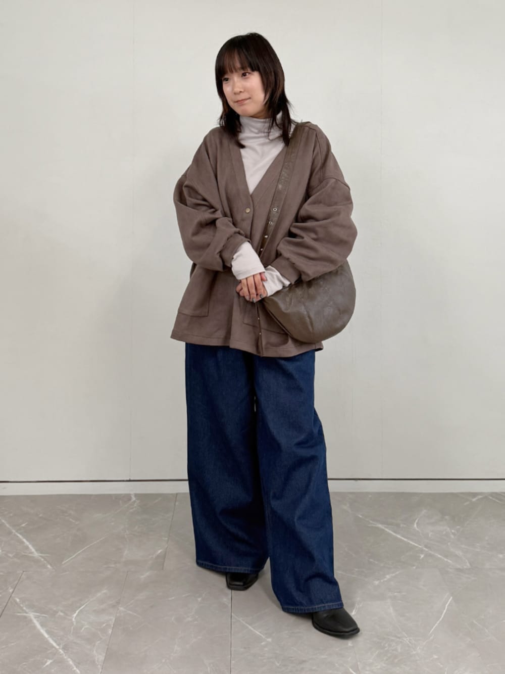 ブラウン系のカーディガン/ボレロ、ブルー系のデニムパンツ、ベージュ系のTシャツ/カットソーを着用したレディースの秋コーディネートの1枚目の写真