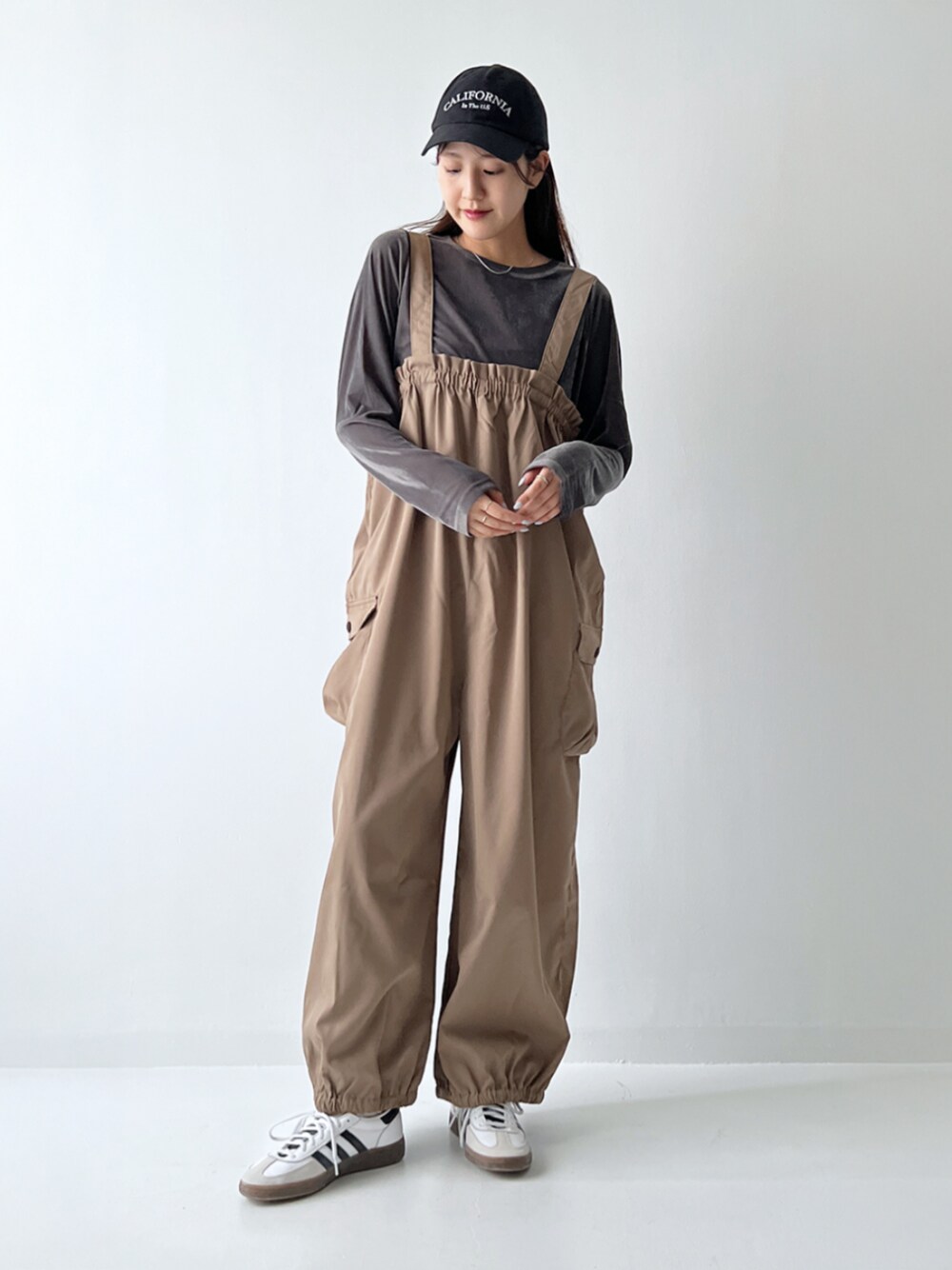 ベージュ系のサロペット/オーバーオール、グレー系のTシャツ/カットソーを着用したレディースの秋コーディネートの1枚目の写真