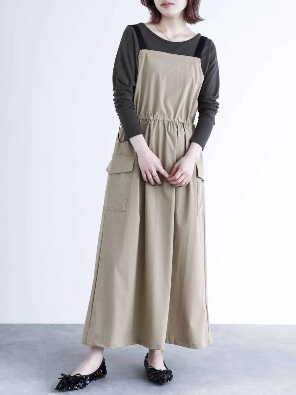 グレー系のTシャツ/カットソー、ベージュ系のジャンパースカートを着用したレディースの夏コーディネートの1枚目の写真