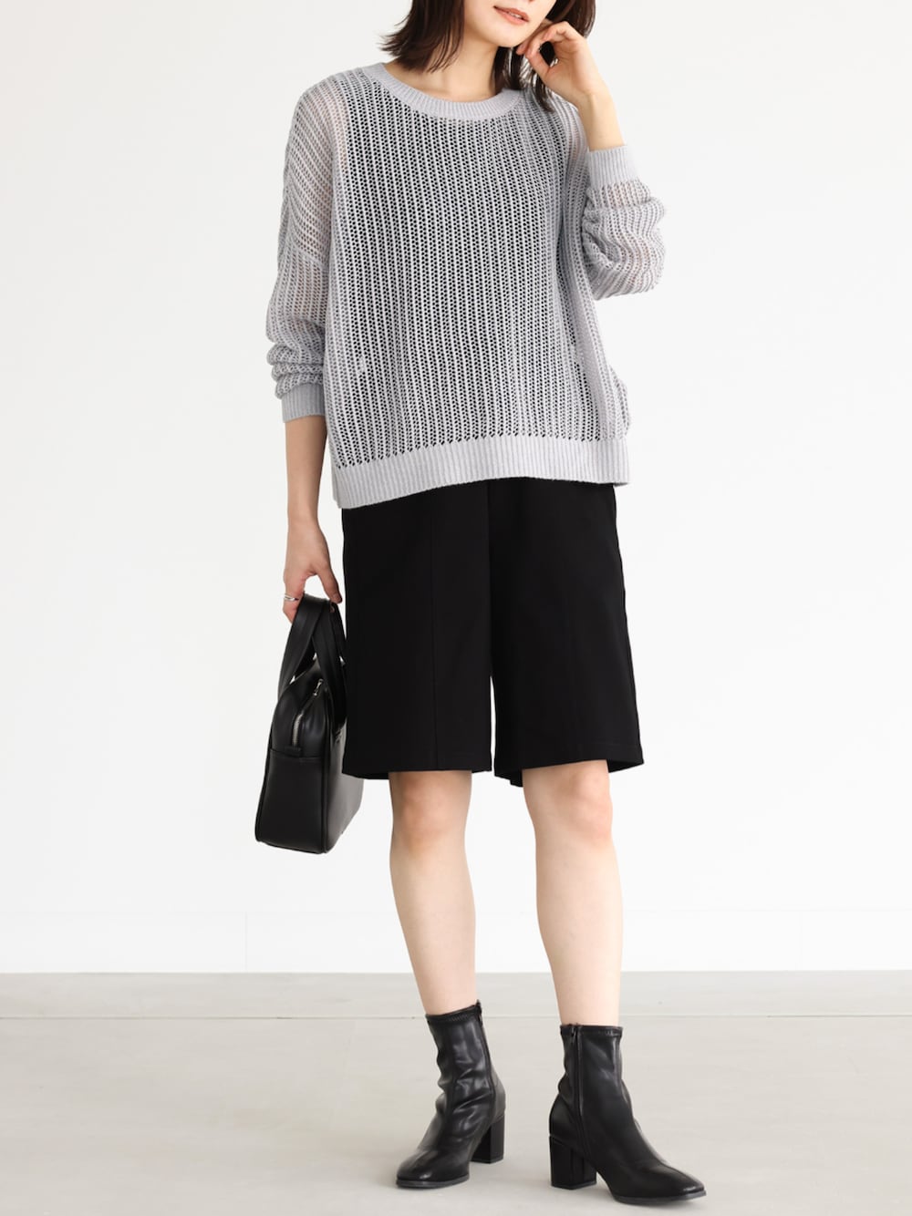 ブラック系のチノパンツ、グレー系のニット/セーター、ブラック系のタンクトップを着用したレディースの秋コーディネートの1枚目の写真