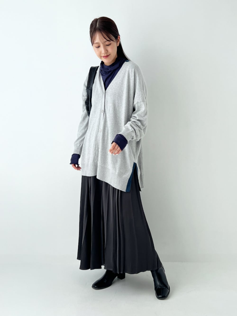 ブルー系のTシャツ/カットソー、グレー系のカーディガン/ボレロ、ブラック系のスカートを着用したレディースの秋コーディネートの1枚目の写真