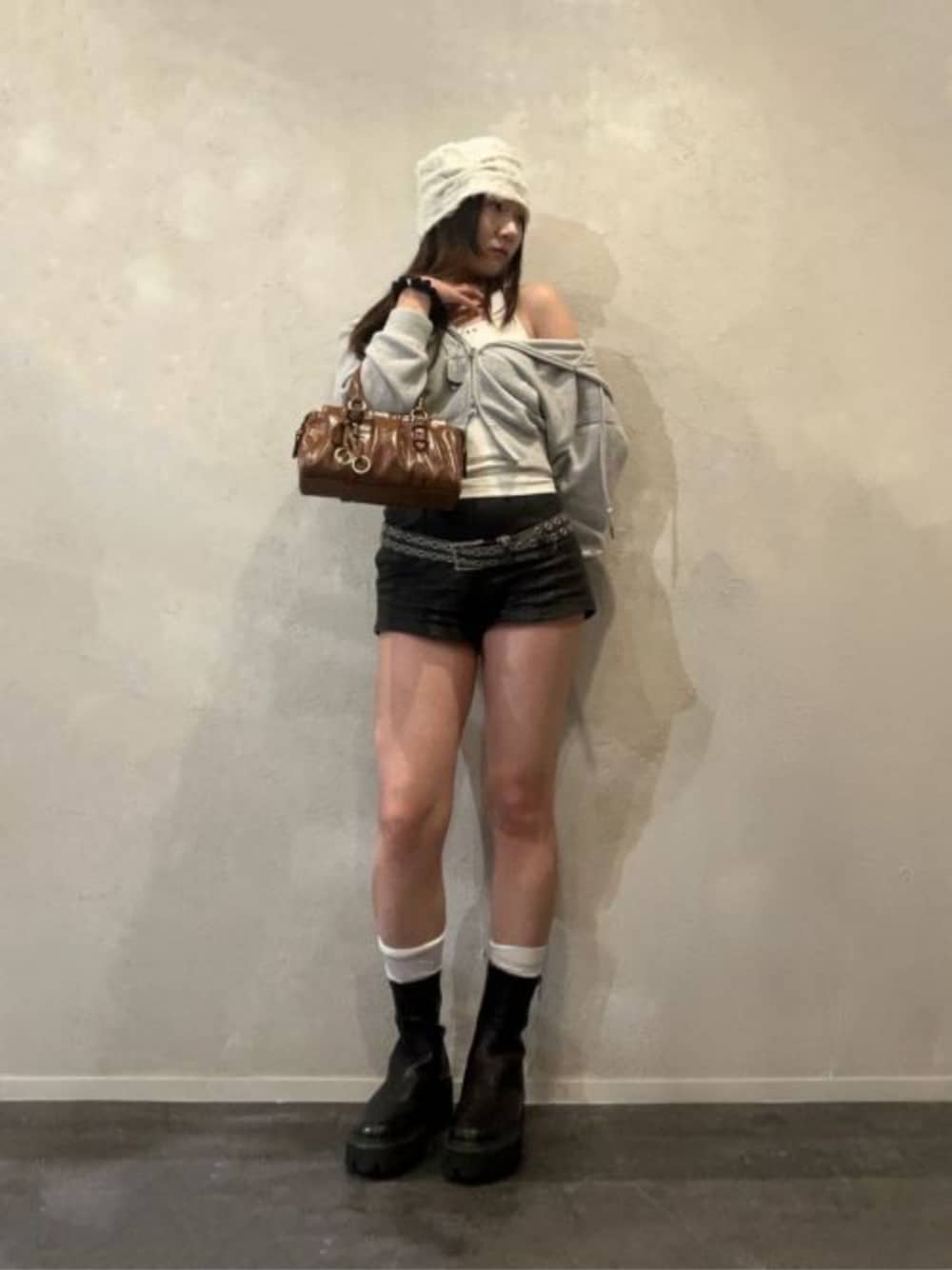 ブラック系のブーツ、ブラウン系のトートバッグを着用したレディースの秋コーディネートの1枚目の写真