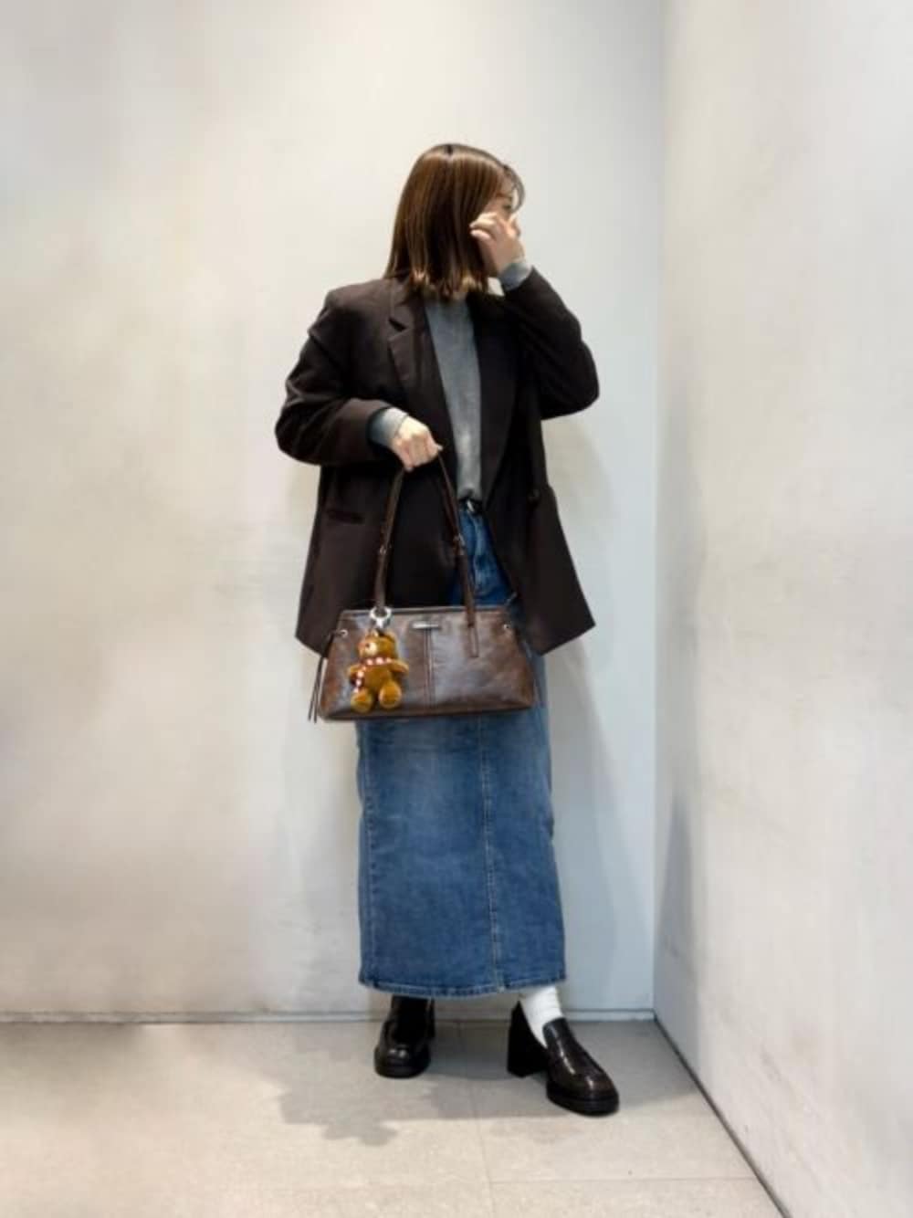 ブラウン系のローファー、ブラウン系のショルダーバッグ、その他のキーケース/キーアクセサリーを着用したレディースの秋コーディネートの1枚目の写真